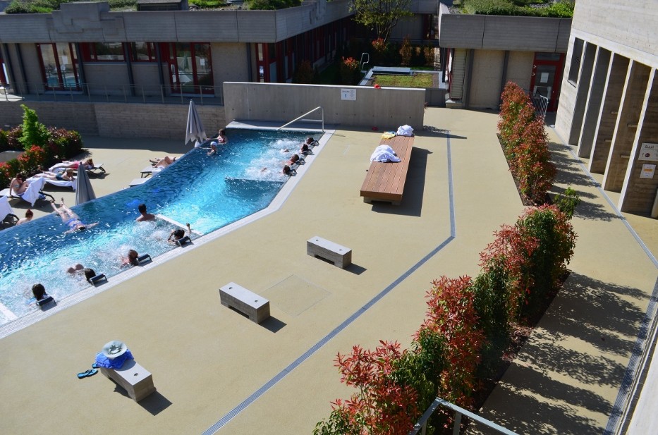 Außenbereich der Schwimmbad Anlage aus Farbasphalt in Sandgelb